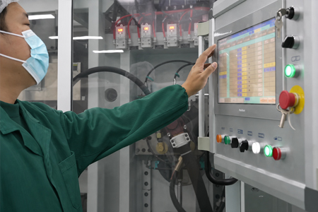 Production technician monitoring automated foodservice packaging equipment through a digital control panel